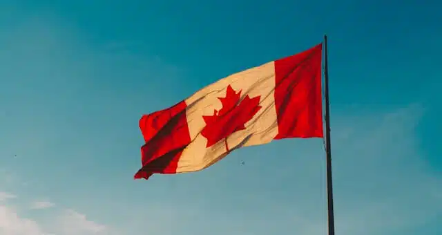 Canadian flag waving against blue sky