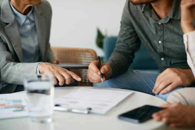 People discussing documents at a table.