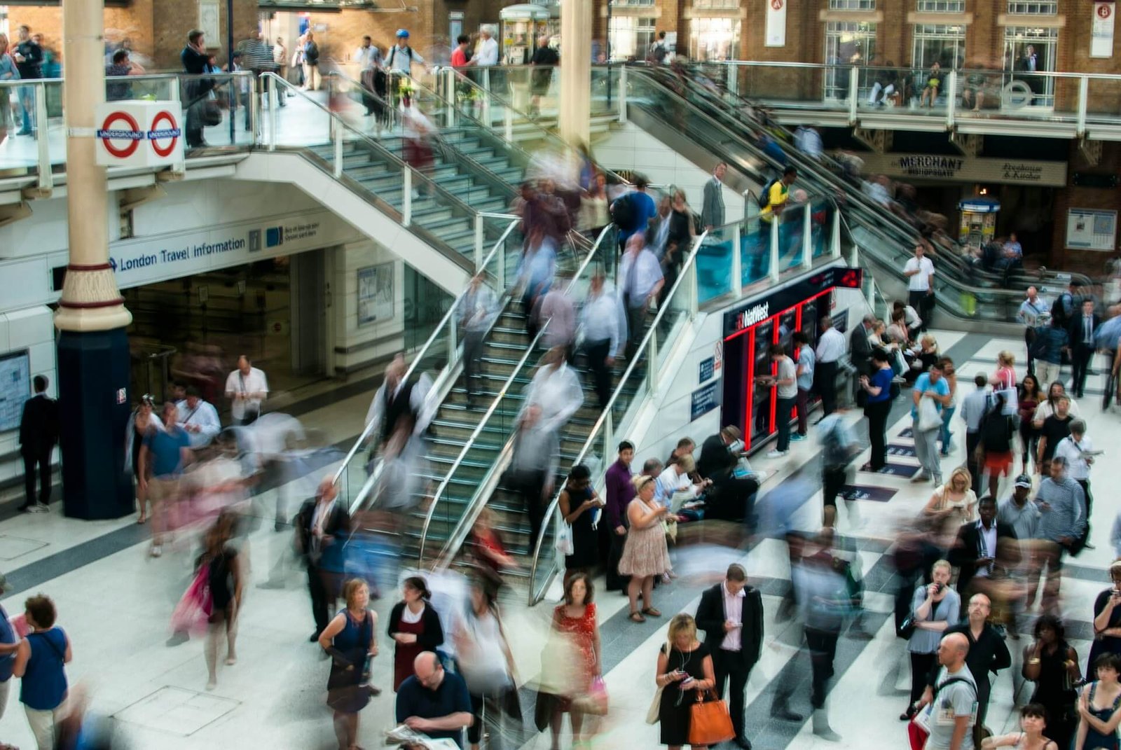 Busy train station with blurred commuters moving