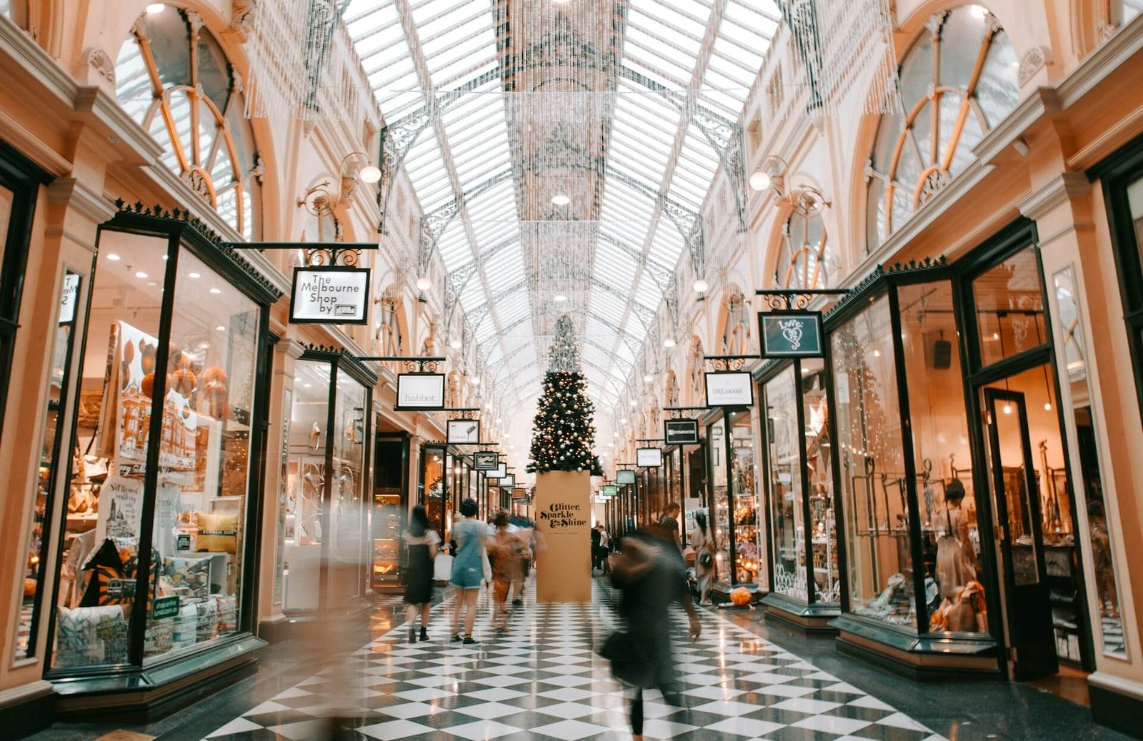 Crowded shopping mall with holiday decorations.