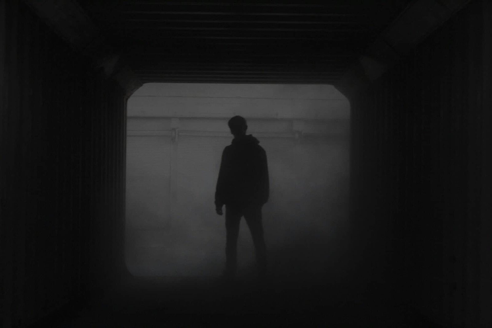 Silhouette of person in foggy tunnel