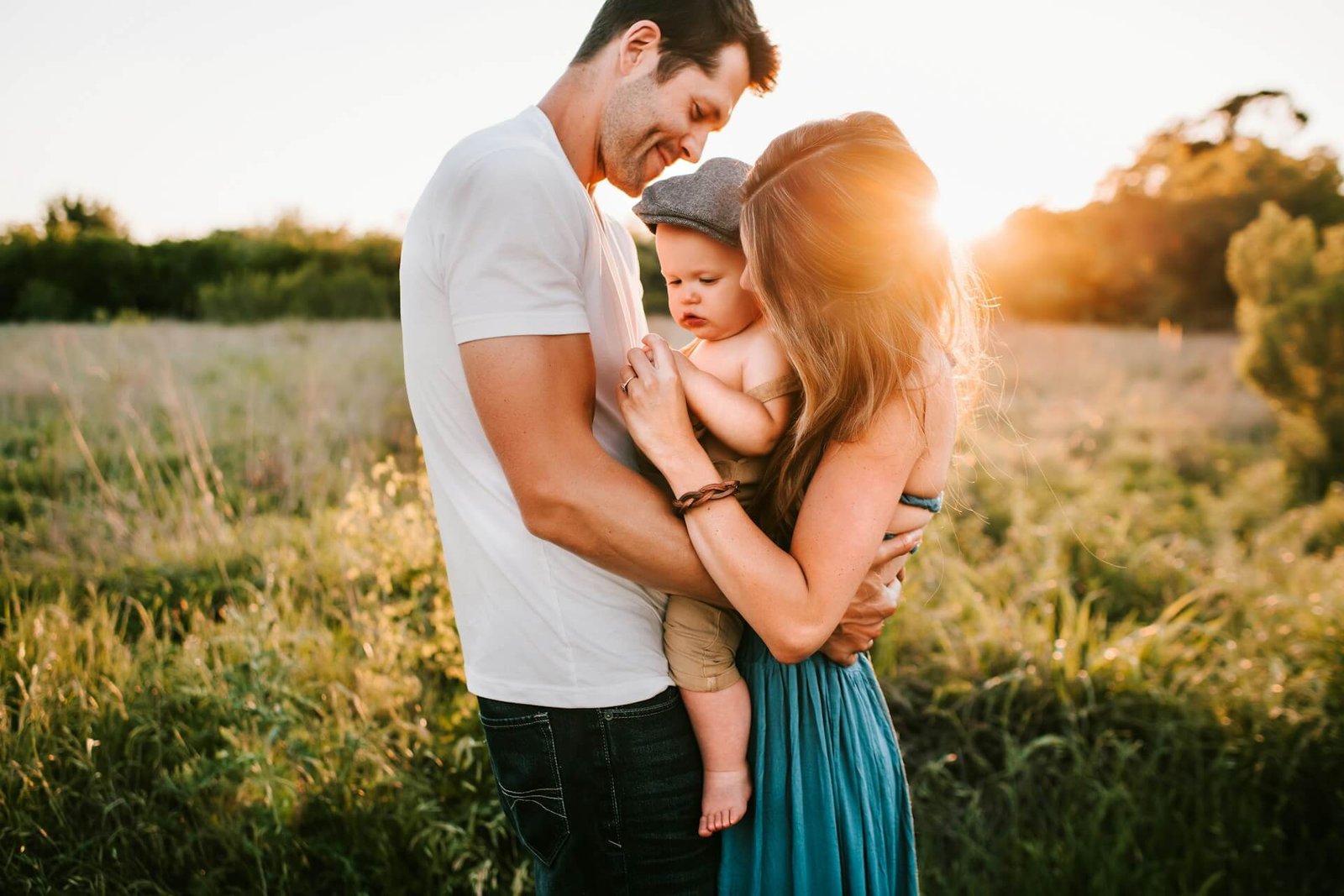 Family embraces in sunny field